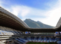 Open-air Football Stadium with Blue and White Seats and a Mountain Backdrop Under a Clear Sky | Tu Colonia Nuevo León