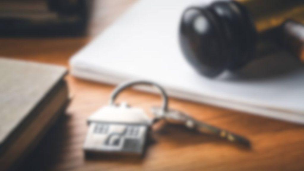 Pedro-davila-hablo-sobre-los-retrasos-inmobiliarios | Tu Colonia Nuevo León Padlock and Key on a Wooden Desk with Papers and Headphones in the Background, Signaling Security or Privacy. | Tu Colonia Nuevo León