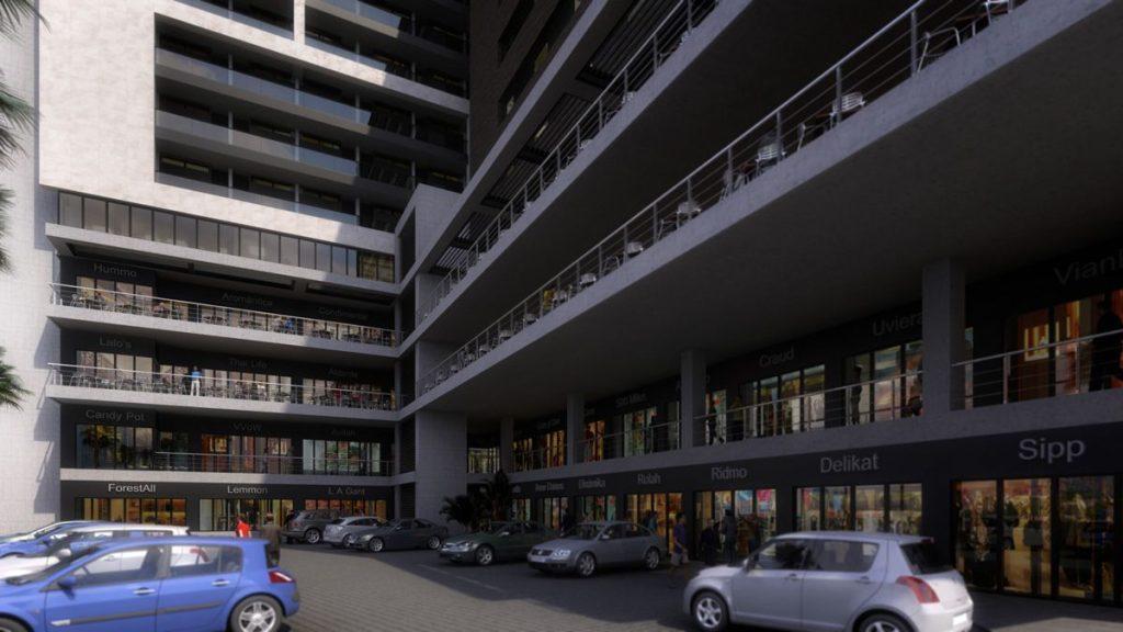 Sadrach-santos-entrevisto-a-pedro-davila-en-posta-talks | Tu Colonia Nuevo León Modern Multi-story Shopping Center with Glass Storefronts on the Ground Level and Balconies Above; Cars Parked in a Paved Lot. | Tu Colonia Nuevo León