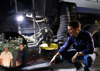 Mechanic crouching beside a large truck undercarriage at night; inset shows two men posing at a nighttime roadwork scene.